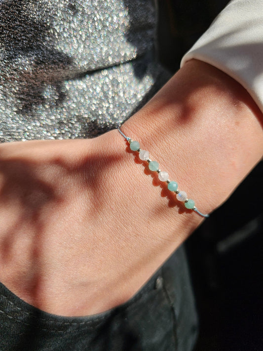 Handmade Amazonite and Moonstone bracelet with sterling silver beads and adjustable cord. Natural gemstones promoting calm, balance, and inner wisdom.