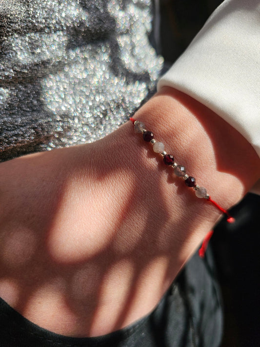 Handmade labradorite and garnet bracelet with sterling silver beads. Adjustable cord for comfort.