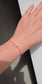 Close-up of a 6mm stardust effect sterling silver bead showing diamond-like sparkle on red cord.