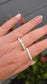 A stack of two delicate rice pearl elastic rings in sizes 3-4mm and 4-5mm on a model's finger, creating a beautiful, cascading luxury jewelry effect.