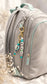 Handmade personalised bag charm with colourful beads and hot-air-balloon detail attached to a stylish gym bag.