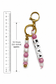Delicate silicone keychain with pearl beads, pastel pink accents and gold details styled with keys on a cream ceramic dish.
