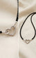 A woman wearing a delicate black tourmaline protection necklace with the silver heart pendant styled at the front.
