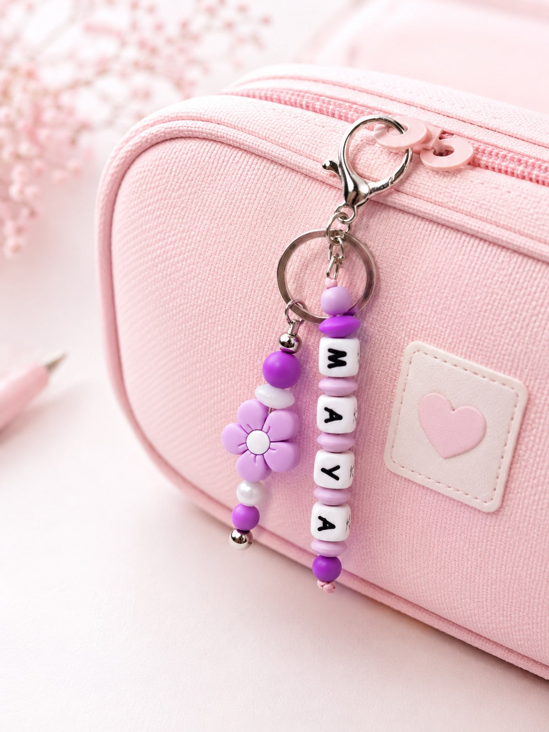 Personalised silicone name charm shown on a school backpack, lunch bag, sports bag and keys, demonstrating its versatile everyday use.

