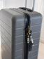 Personalised surname luggage tag on a black backpack and travel bag, stylish custom accessory for adults travelling through an airport.
