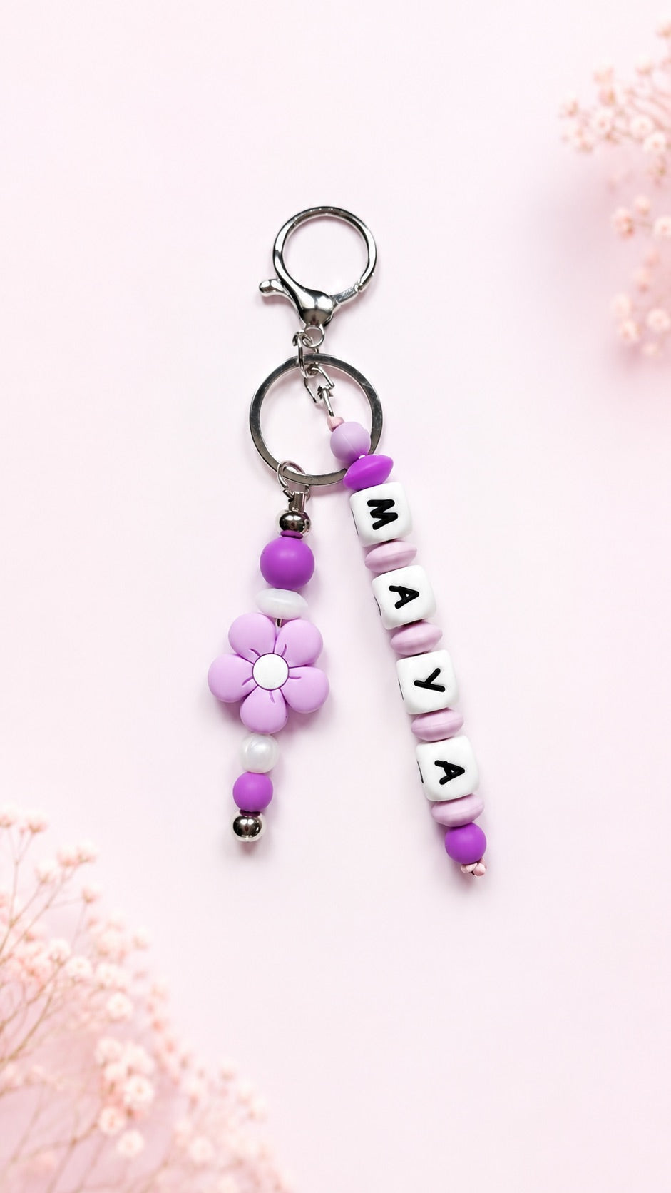 Personalised name bag charm made with soft silicone beads, clipped to a children's school backpack, perfect for identifying their bag at school.
