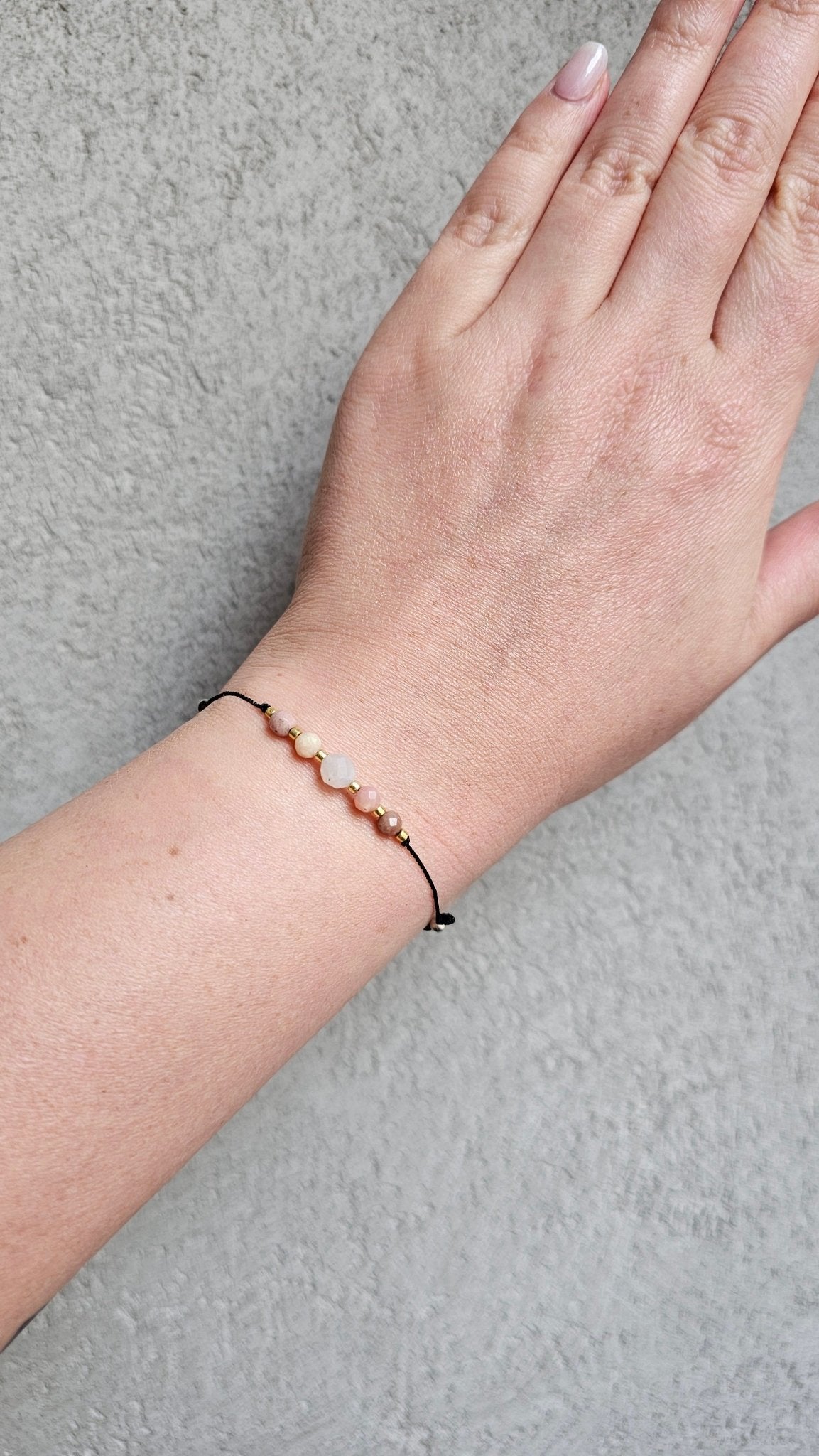 Handmade lucky bracelet with natural Moonstone, Pink Opal, and Rhodonite stones on a delicate pink nylon cord, featuring sterling silver stoppers and sparkling TOHO glass beads. Adjustable, stylish, perfect for love, emotional healing, protection, and spiritual growth. Ideal gift for her.

