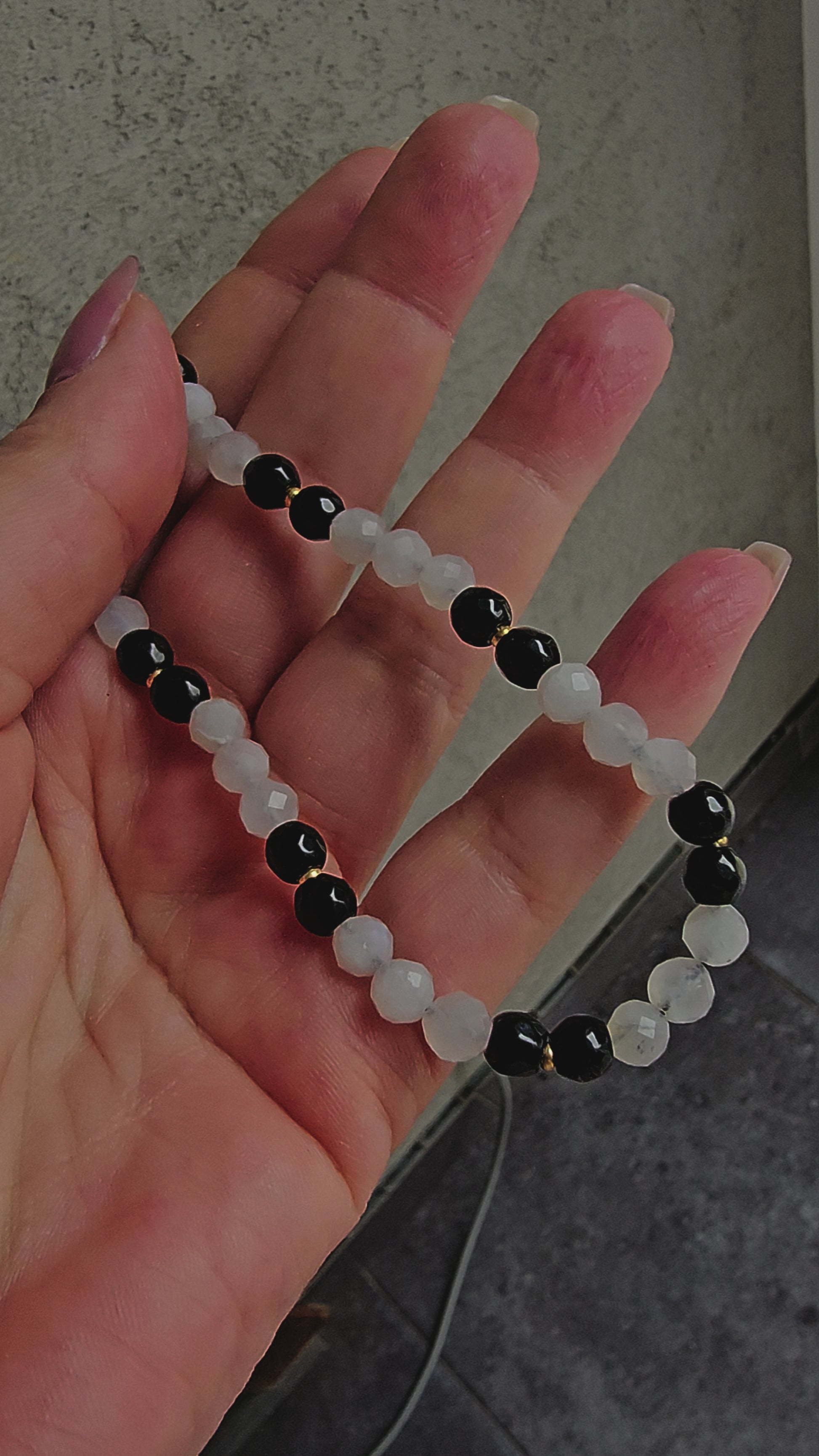 rotective crystal charm with black onyx & moonstone. Calming, fidget-friendly and perfect for your phone, keys, or bag. Handmade with meaning.
