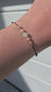 Handmade lucky bracelet with natural Moonstone, Pink Opal, and Rhodonite stones on a delicate pink nylon cord, featuring sterling silver stoppers and sparkling TOHO glass beads. Adjustable, stylish, perfect for love, emotional healing, protection, and spiritual growth. Ideal gift for her.
